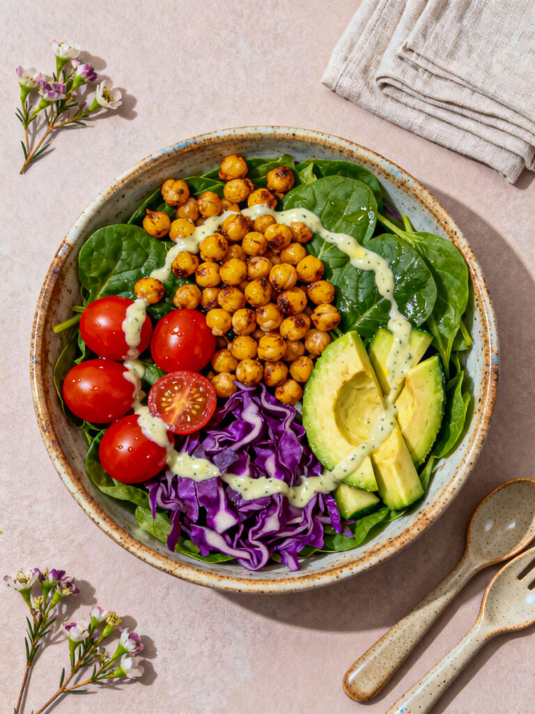 Vegane Bowl mit Avocado, Kichererbsen, Rotkohl, Spinat und Tomaten auf hellem Hintergrund, KI-generiert